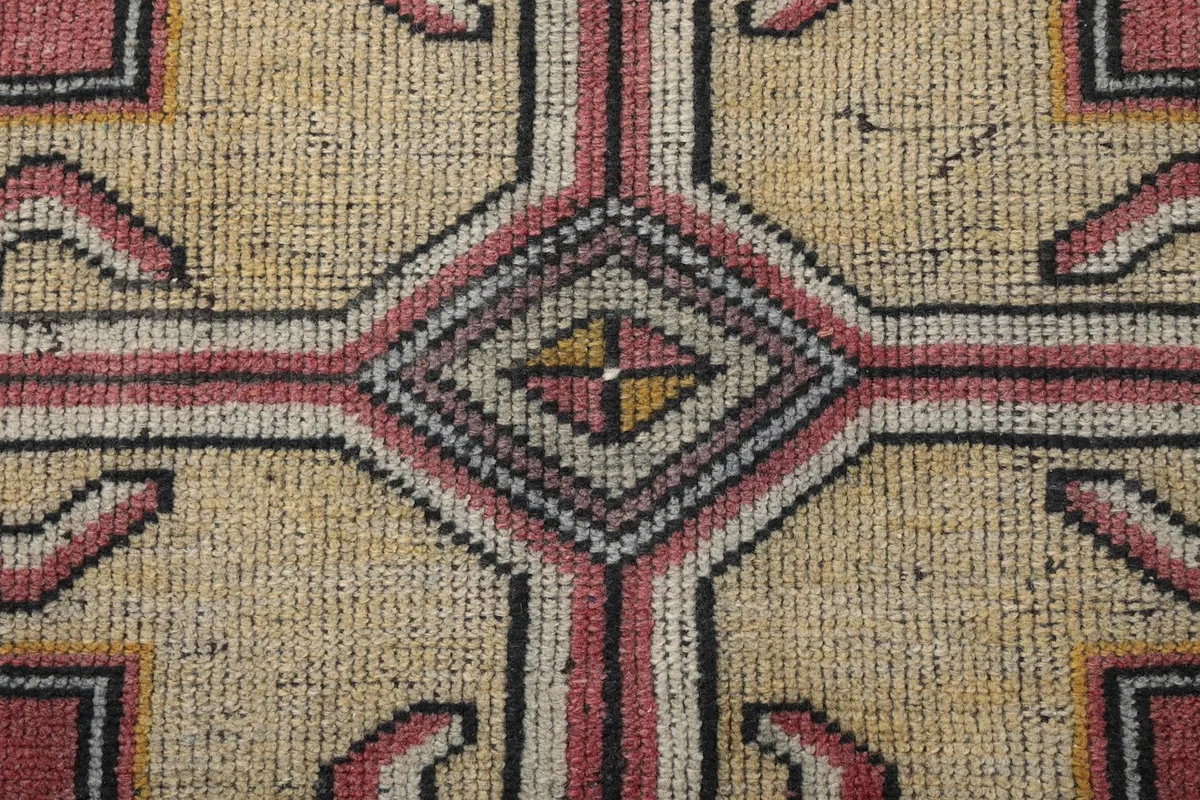 Macro view of the central ivory motif, showcasing the wool pile and subtle color variations
