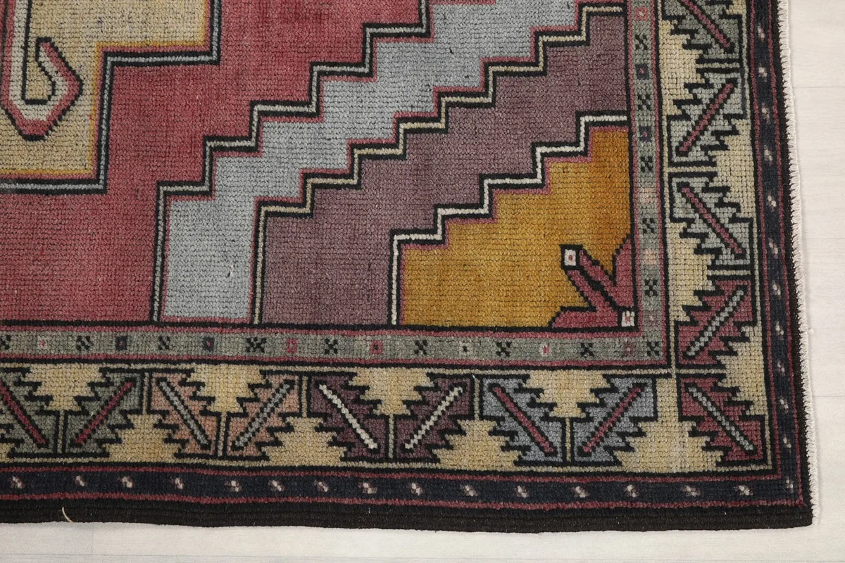 Detailed corner view showing the black, ivory, and gold geometric border patterns