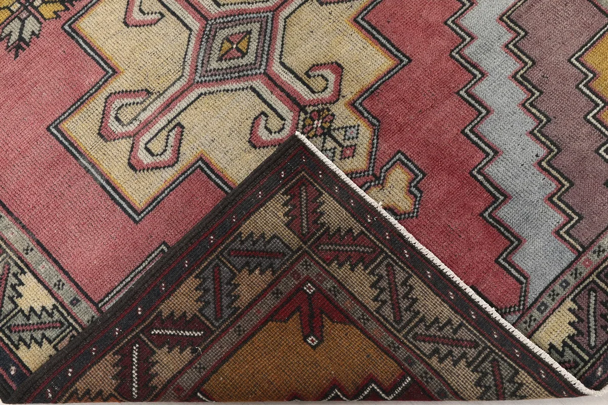 Partial view of the rug's reverse side, showing the hand-knotted cotton foundation