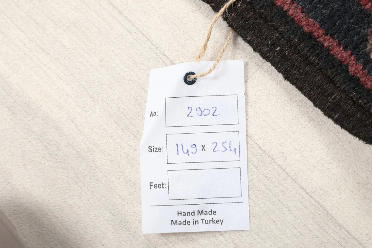 Product tag displaying the rug's dimensions in centimeters and origin