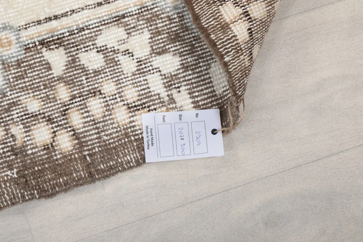 Care label attached to the rug, showing details of its origin and material