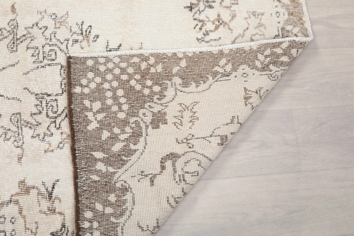 Detail of the rug's reverse side, revealing the knotting and a corner of the design