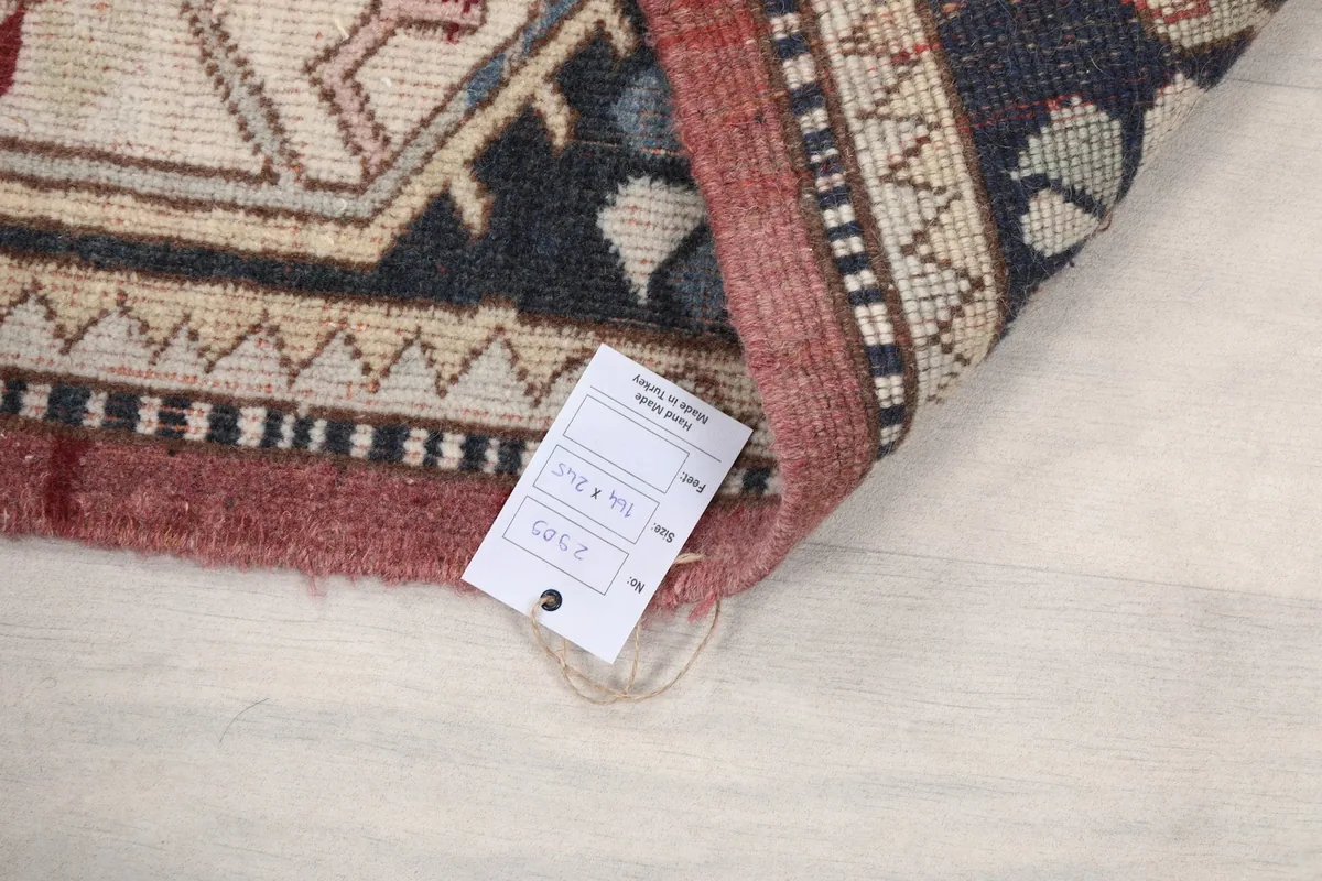 Reverse side of the rug with a size tag, showing the hand-knotted construction