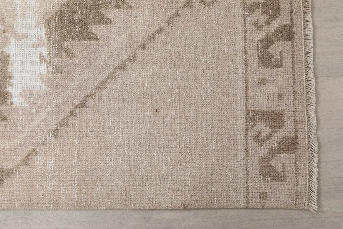 Detailed view of the rug's end border and fringe, showing the wool pile