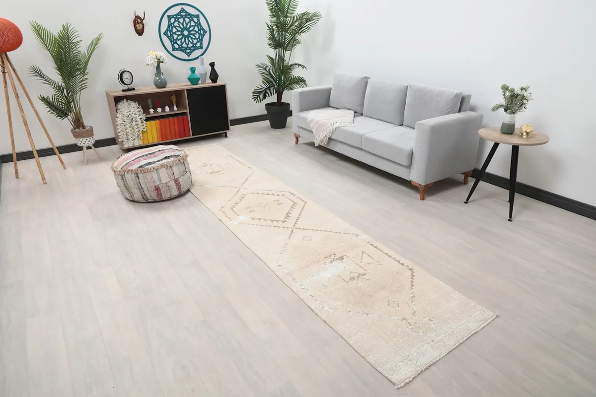 Long view of the ivory and tan geometric runner rug in a hallway setting, showing its full length
