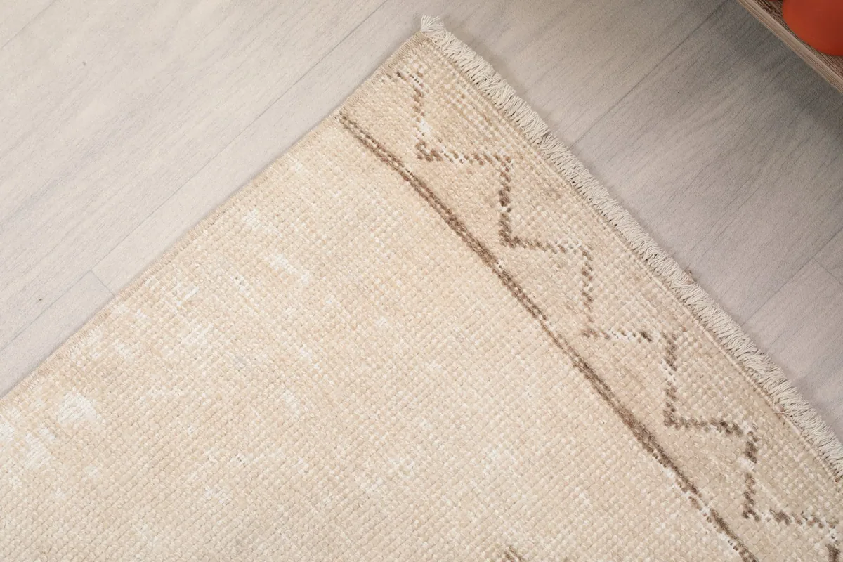 Corner detail of the runner rug showing the subtle border design and natural fringe