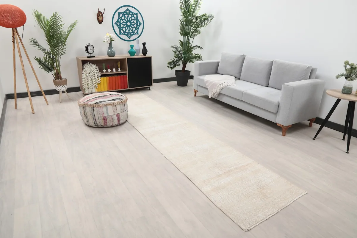 Angle view of the beige runner rug in a room setting, showing its length and subtle color.
