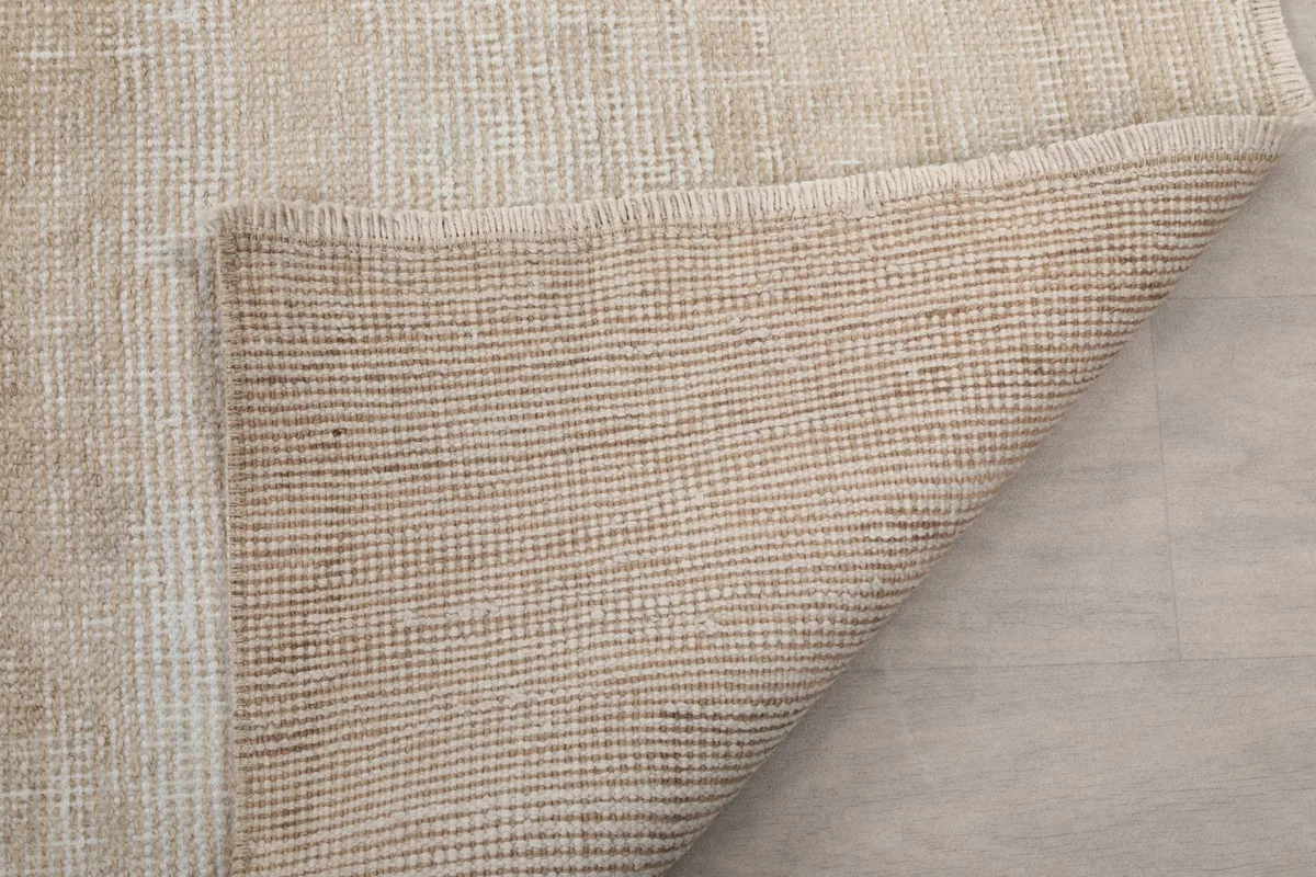 Another view of the rug's reverse side, showing the tight weave of the cotton foundation.