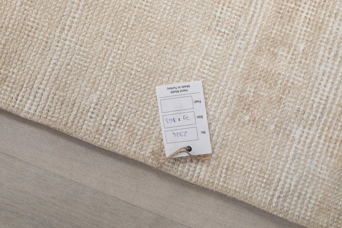 Close-up of the rug's surface with a product tag, showing the texture and color.