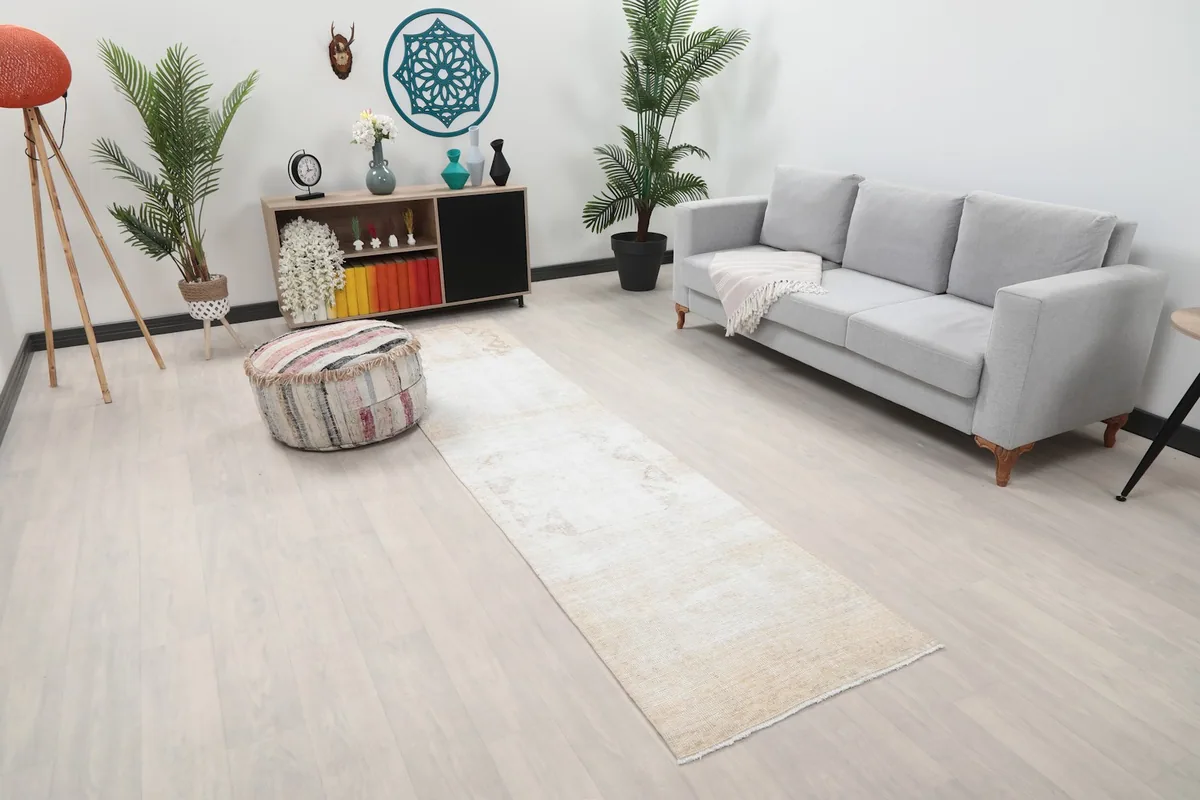 Overhead view of the cream and beige runner rug in a room, showing its length and placement