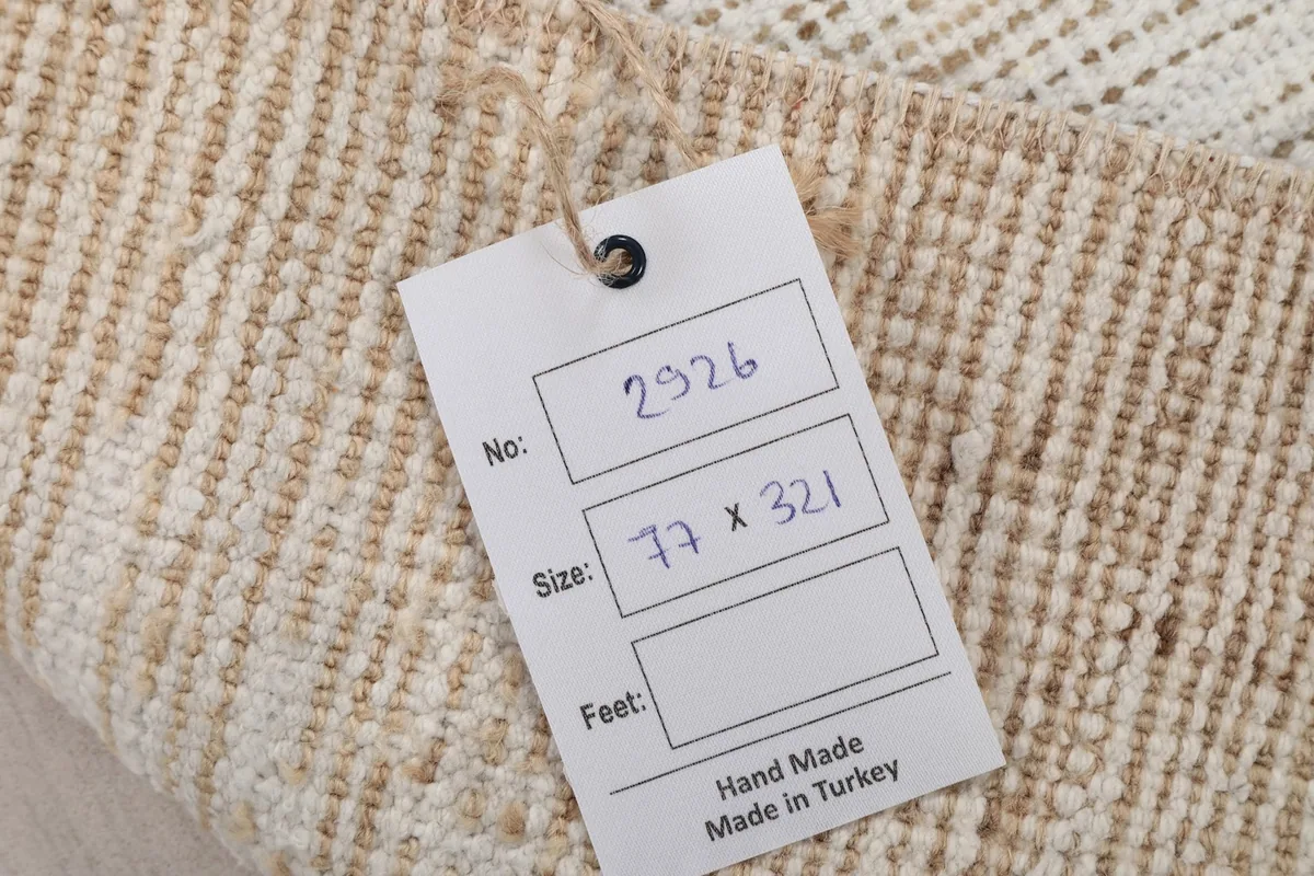 Label showing the rug's identification number and size (77 x 321 cm) on the back of the rug