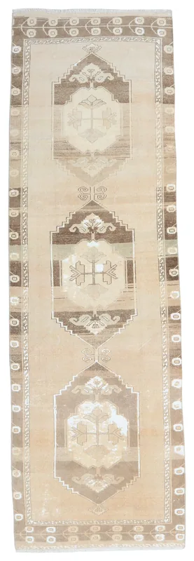 Full top view of the 3'4" x 10'10" beige and brown vintage Anatolian runner rug