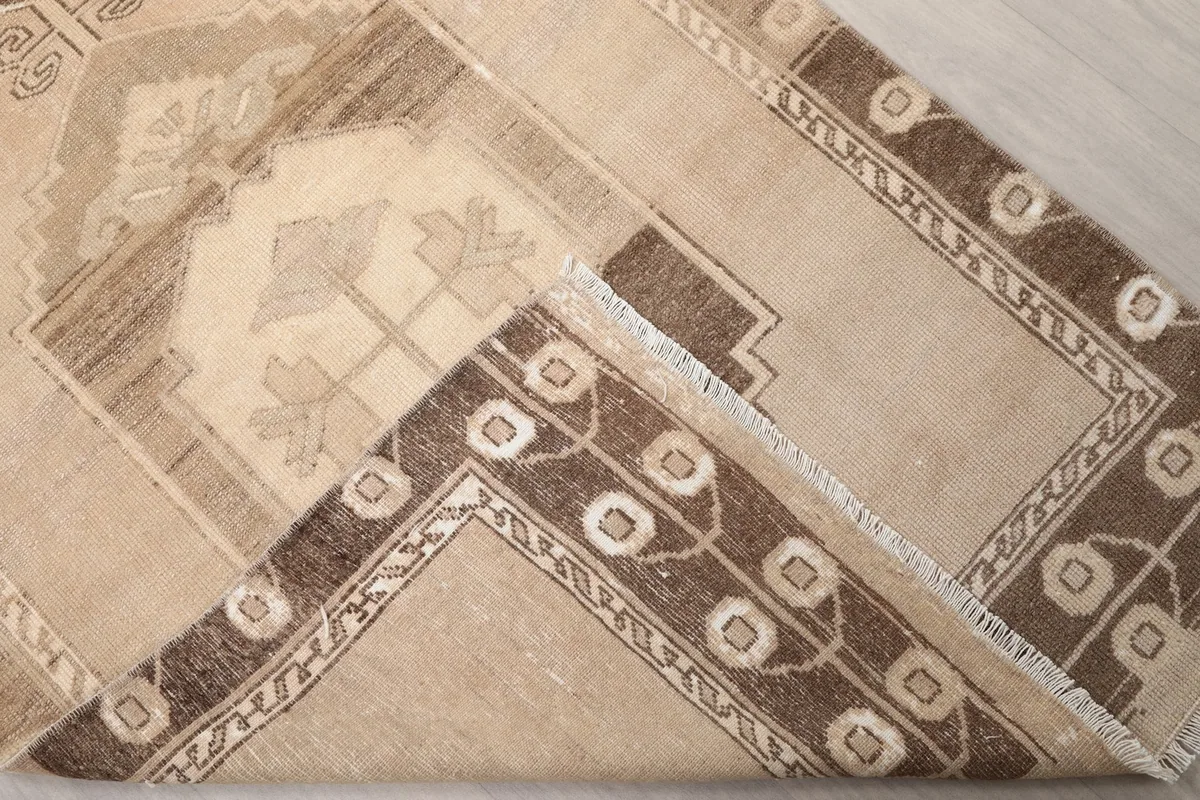 Folded corner of the rug revealing the wool pile on cotton foundation and construction
