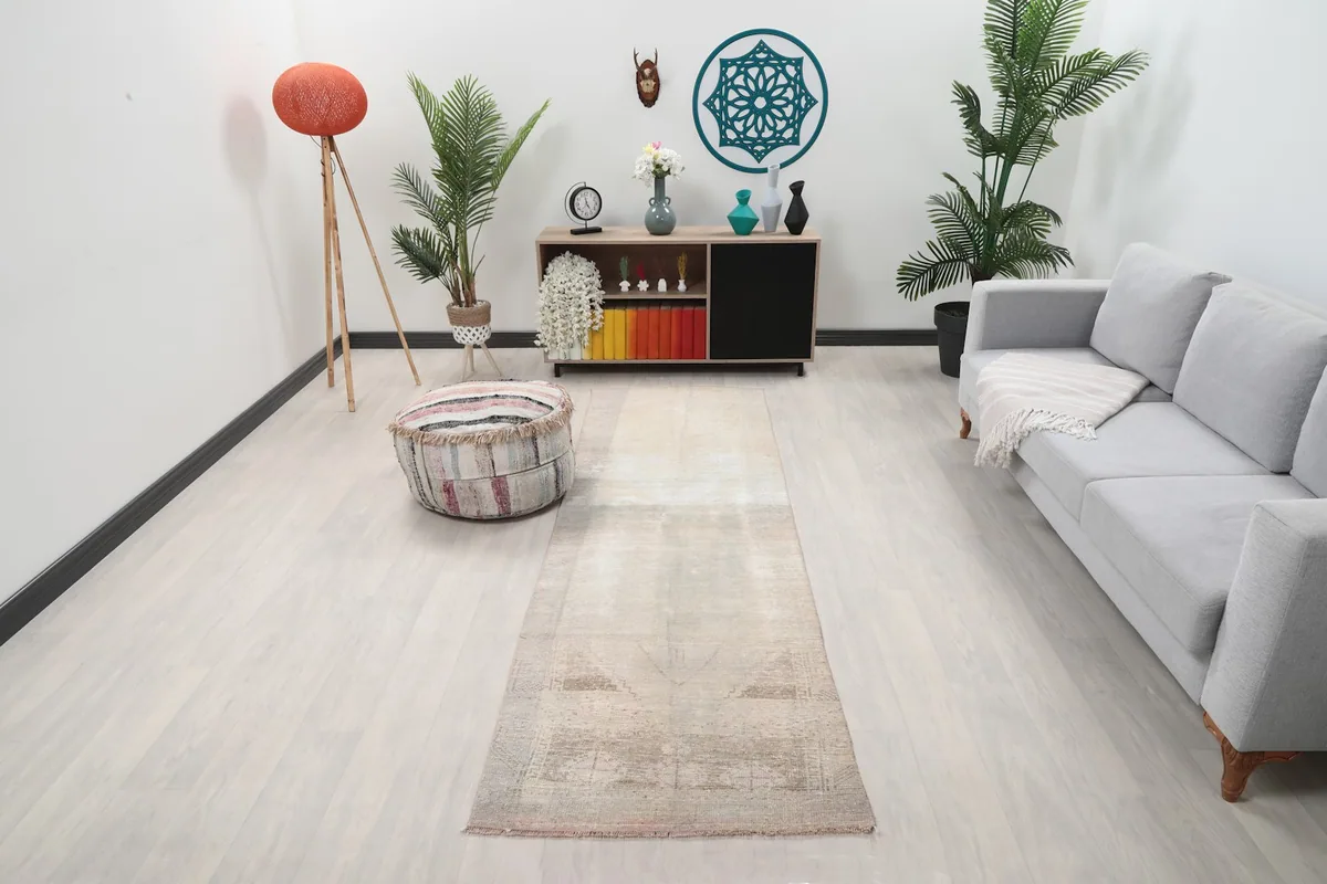 Vintage Anatolian runner rug displayed in a living room setting with modern furniture.