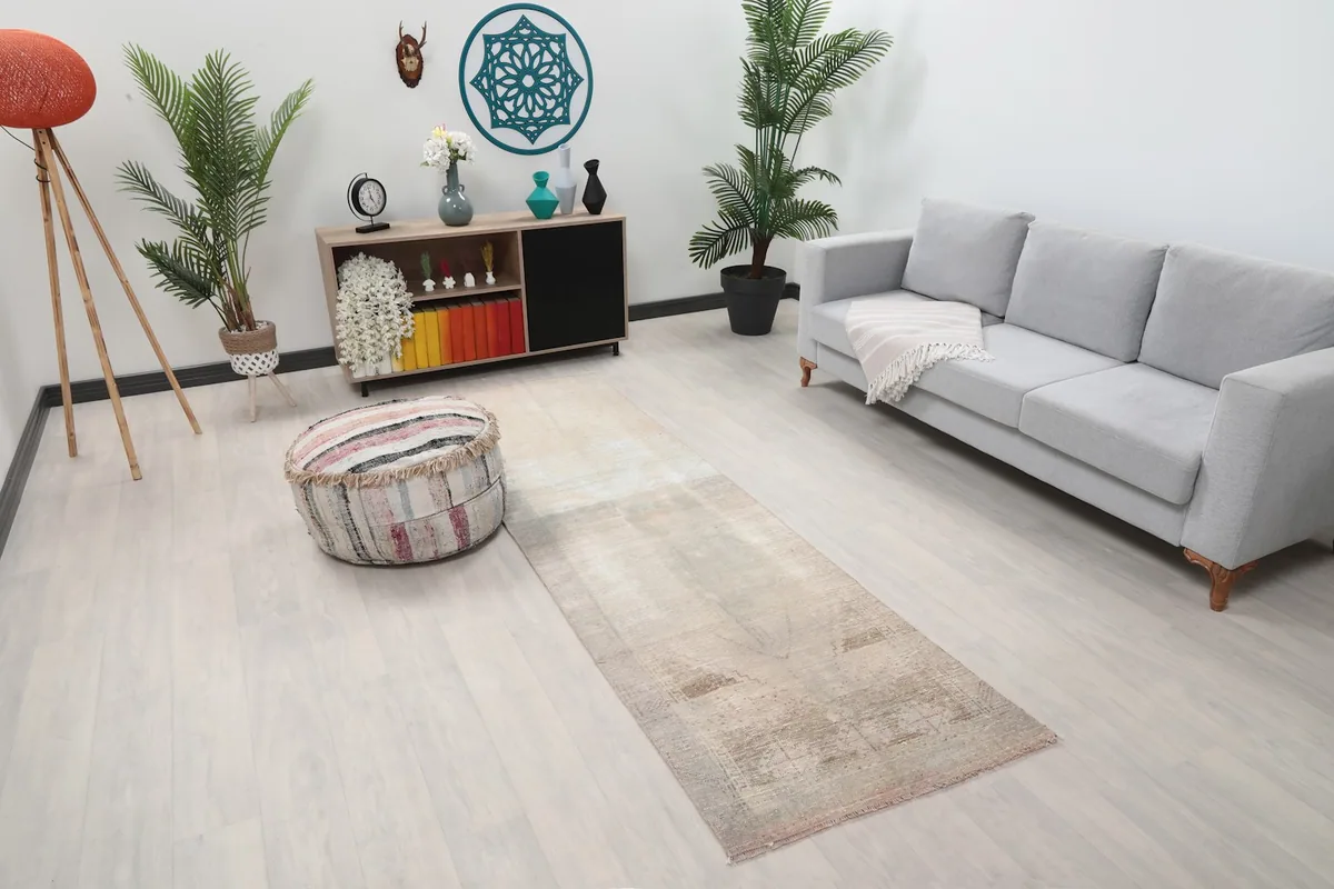Angled view of the runner rug in a room, showing its length and placement next to a sofa.