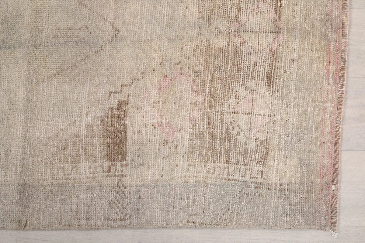 Detailed view of the rug's pattern and subtle color variations, including hints of rust and pink.