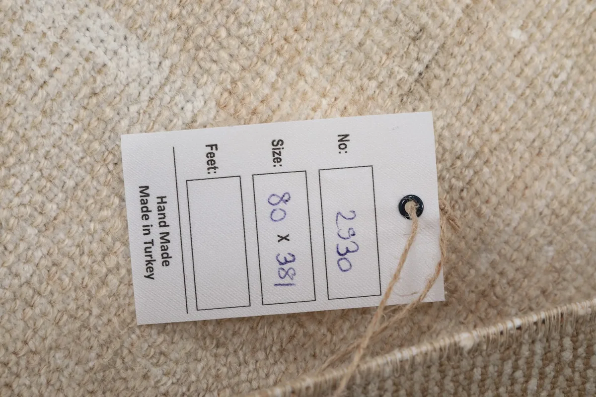 Information tag attached to the rug, showing dimensions and origin