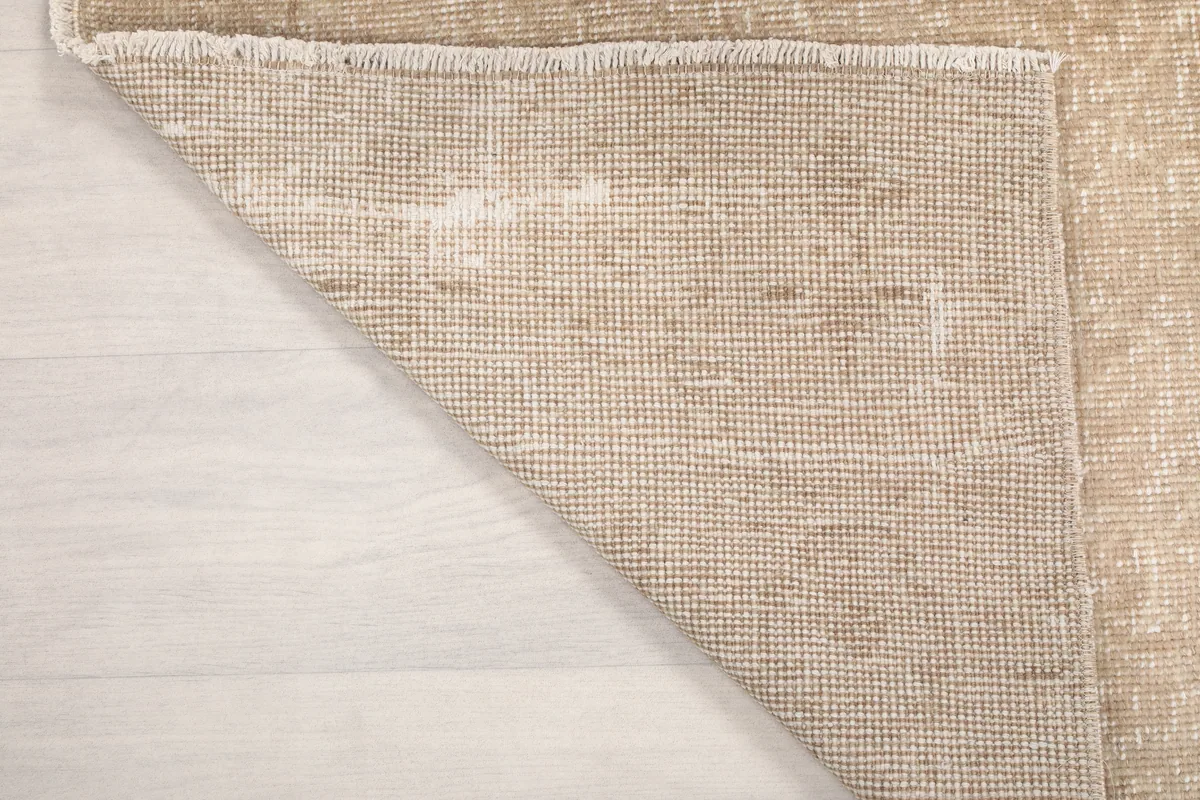 Corner of the Faded Beige Geometric Anatolian Rug's back, showing its construction and fringe.