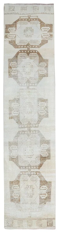 Full top view of the cream and brown geometric Anatolian runner rug on a white background.