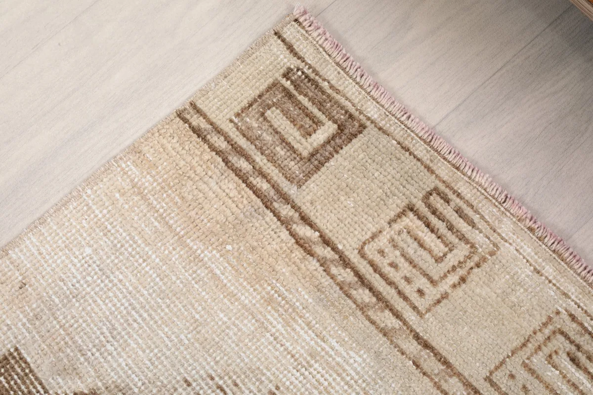 Corner detail of the rug, showing the border design and the edge finishing.