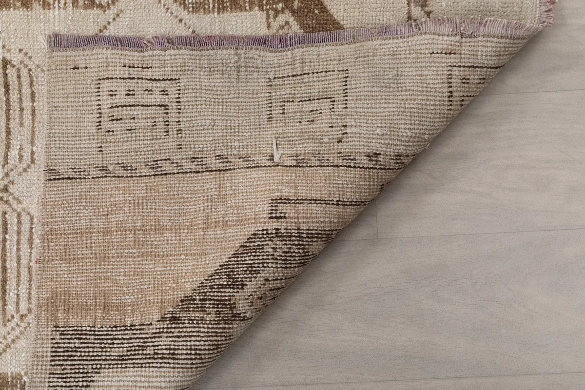Underside view of the rug, displaying the tightly woven cotton foundation and knotting.