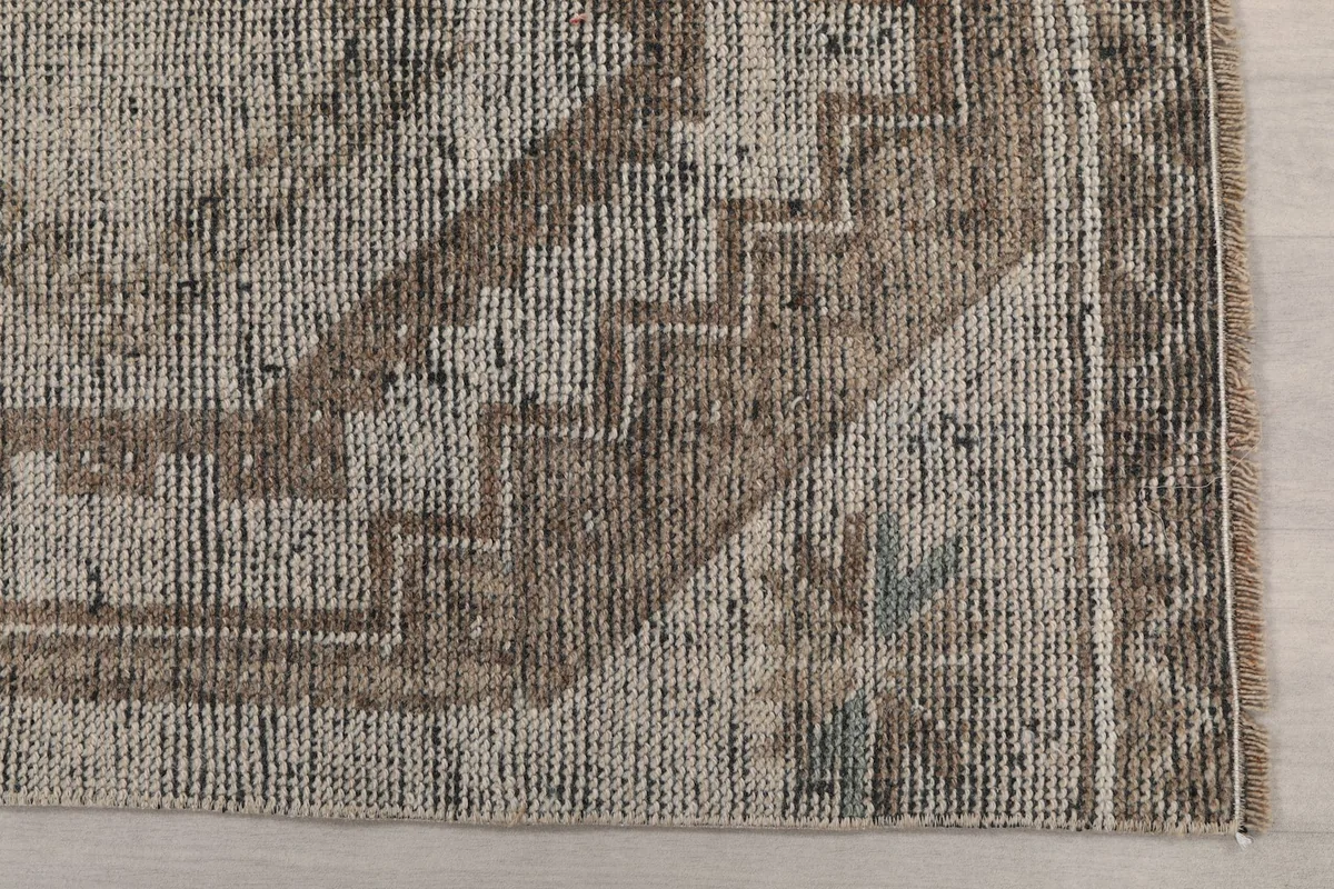 Detailed view of the hand-knotted wool pile and the intricate geometric border design.