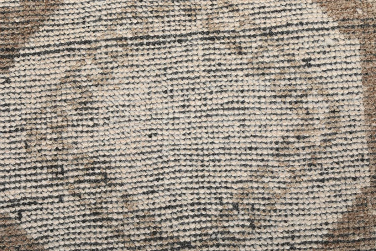 Texture shot of the low wool pile, showing individual knots and the distressed appearance.