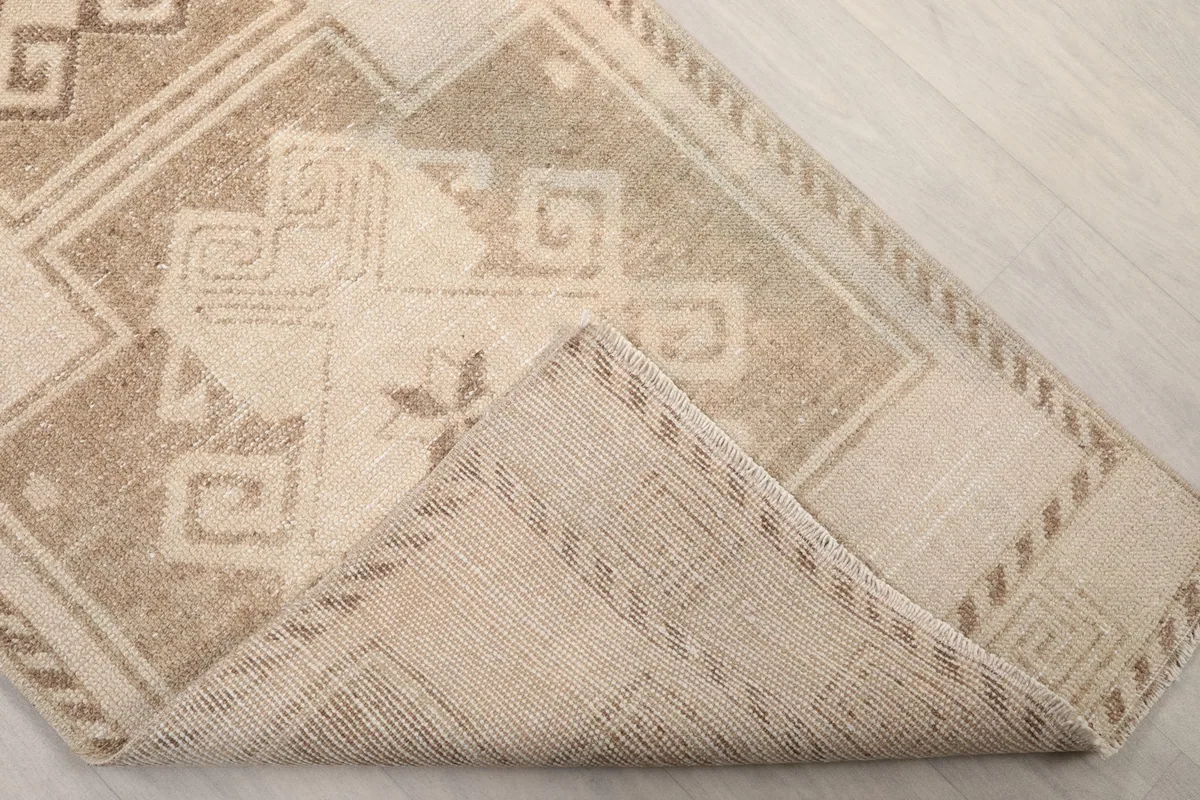 Folded corner showing the reverse side of the hand-knotted wool on cotton foundation