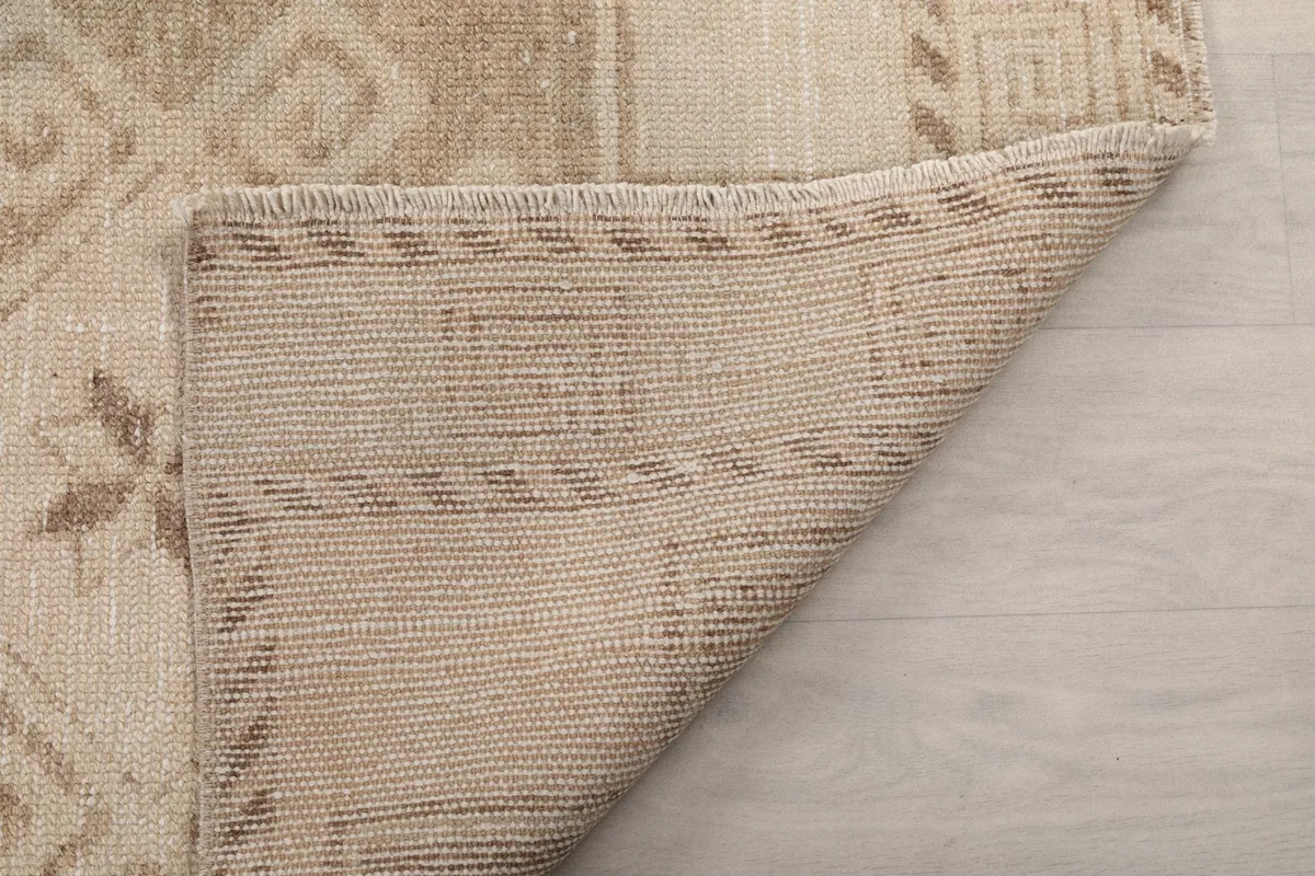 Detailed view of the rug's sturdy cotton foundation and the back of the knotting