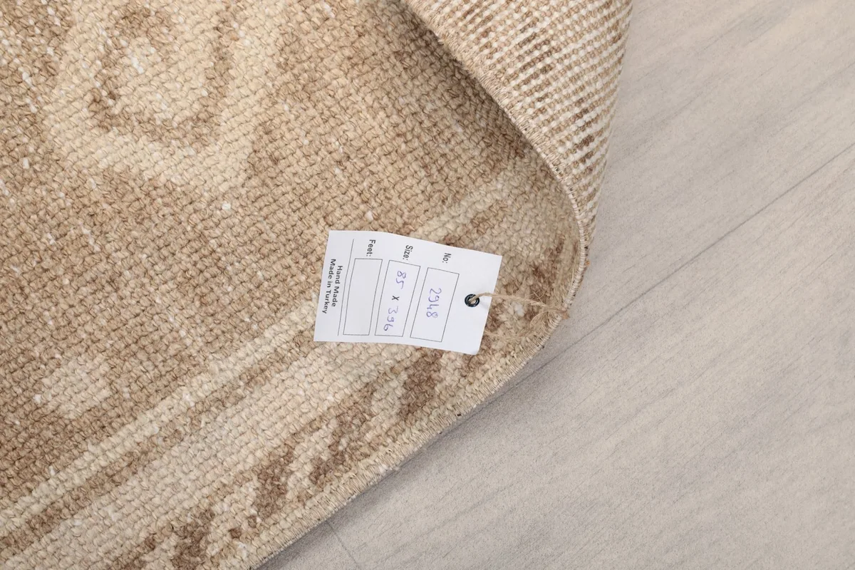 Close-up showing the product tag attached to the back of the vintage hand-knotted runner
