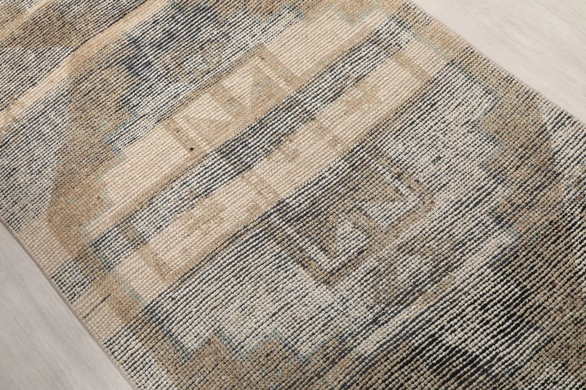 Close-up of the geometric motifs and color variations within the rug pile