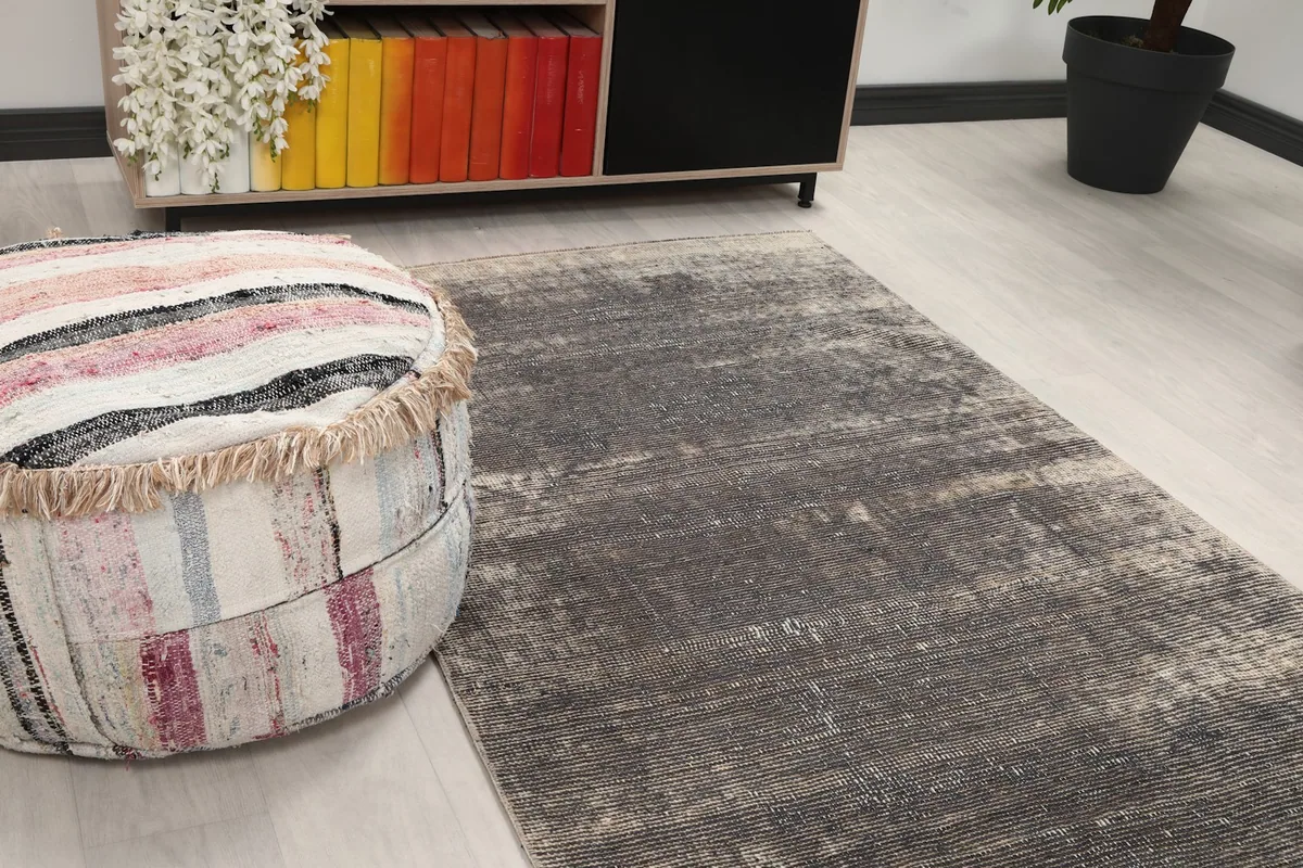 Close-up angle of the rug's texture and colors next to a colorful pouf