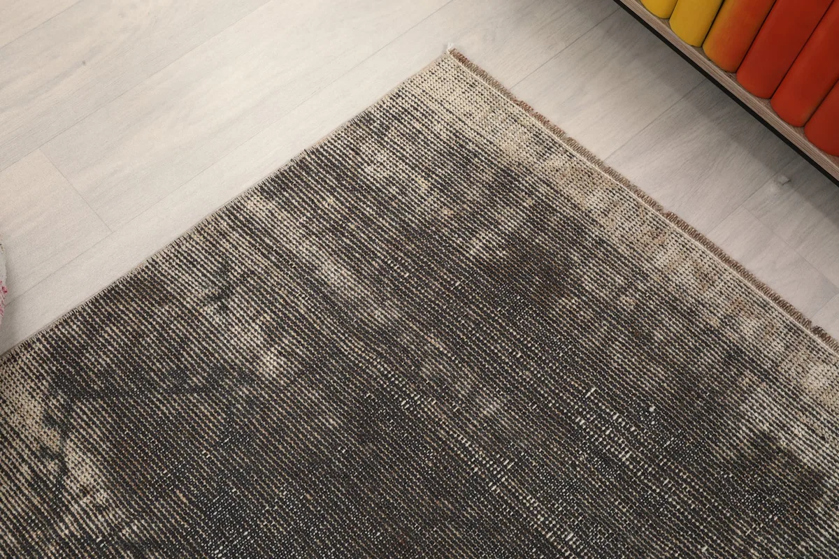 Detail of the rug's edge and the slightly faded, subtle border design