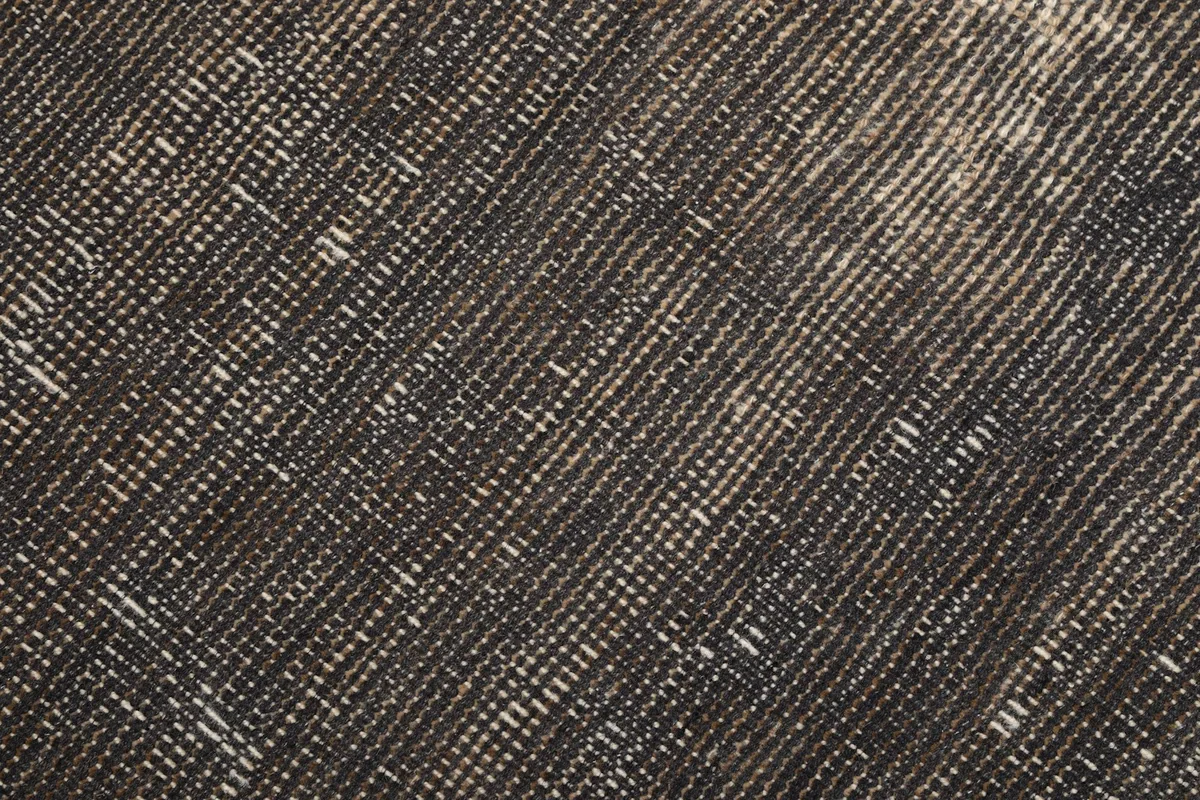 Extreme close-up of the low wool pile and visible cotton foundation