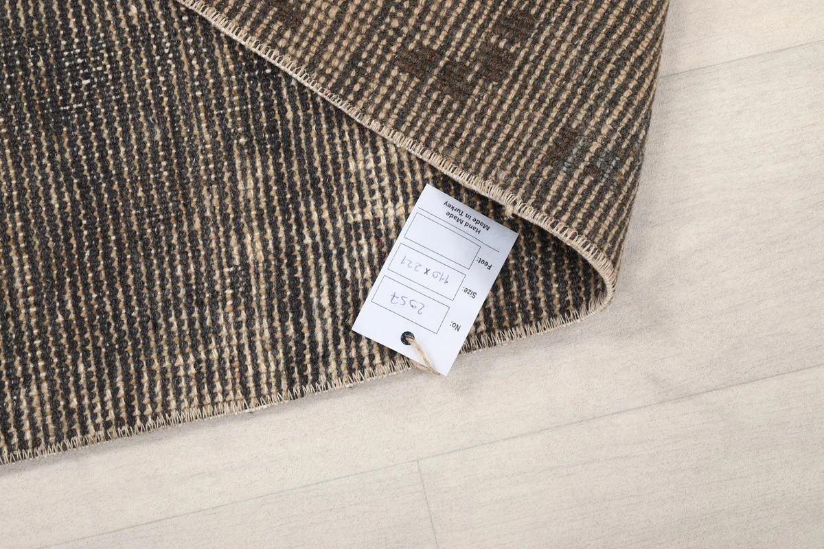 Corner of the rug with a product tag displaying size and material information
