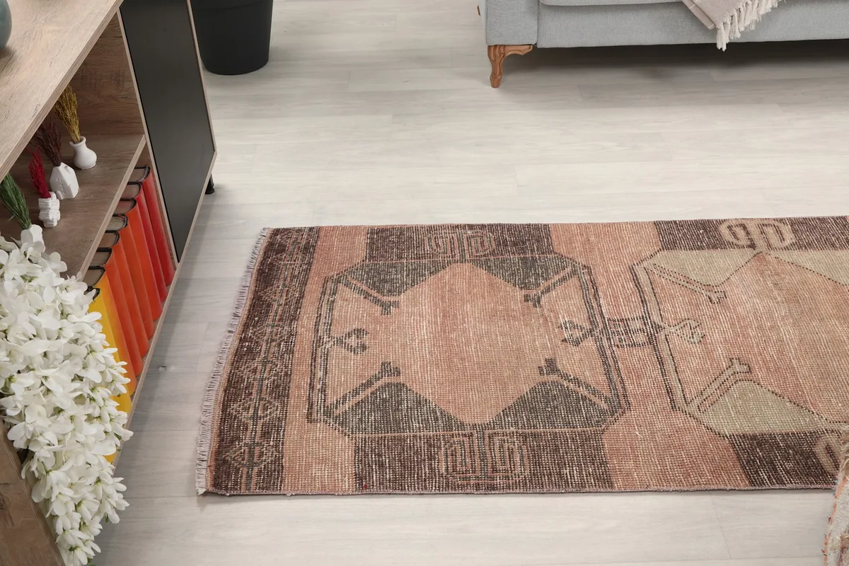 View of the runner rug from the side, extending into a room with a cabinet