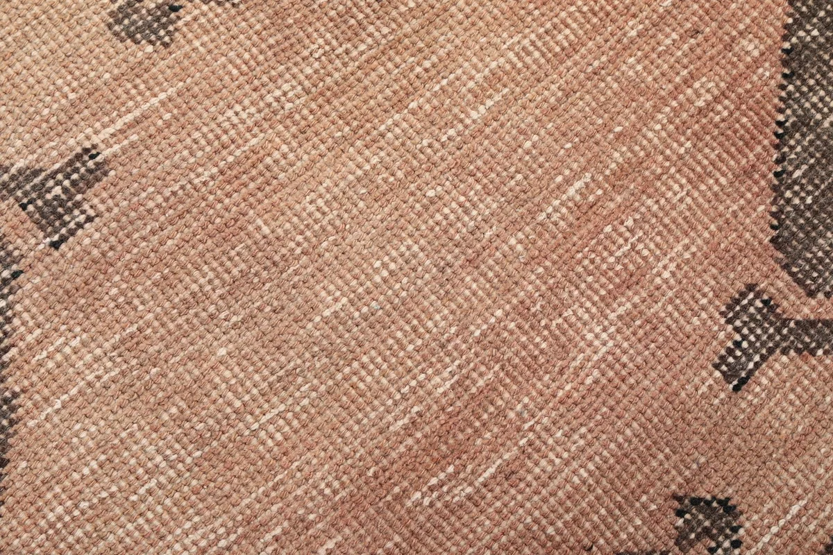 Close-up of the low wool pile texture and distressed appearance of the rug