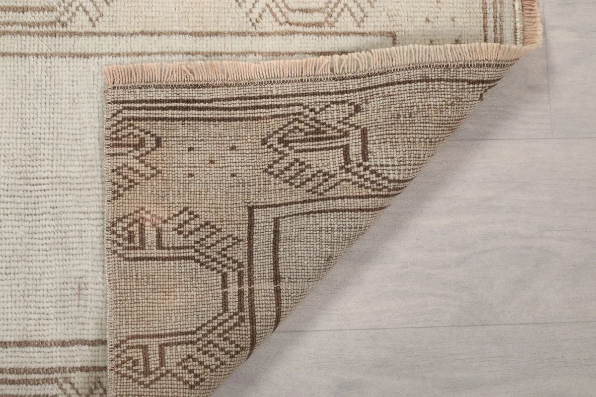 View of the back of the vintage runner rug, showing the cotton foundation and the hand-knotted structure.