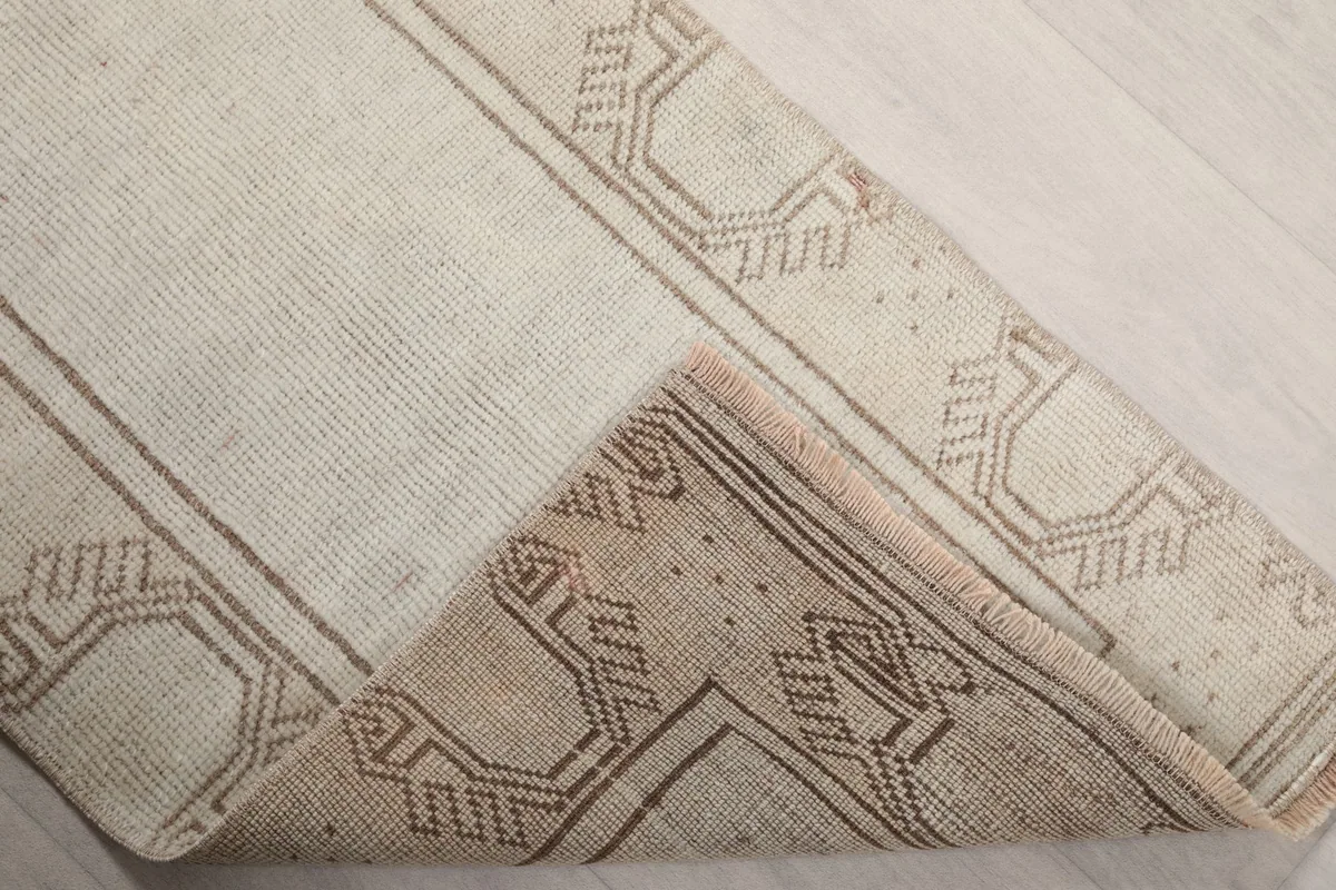 Folded corner of the runner rug, revealing the back of the rug and the density of the hand-knotting.