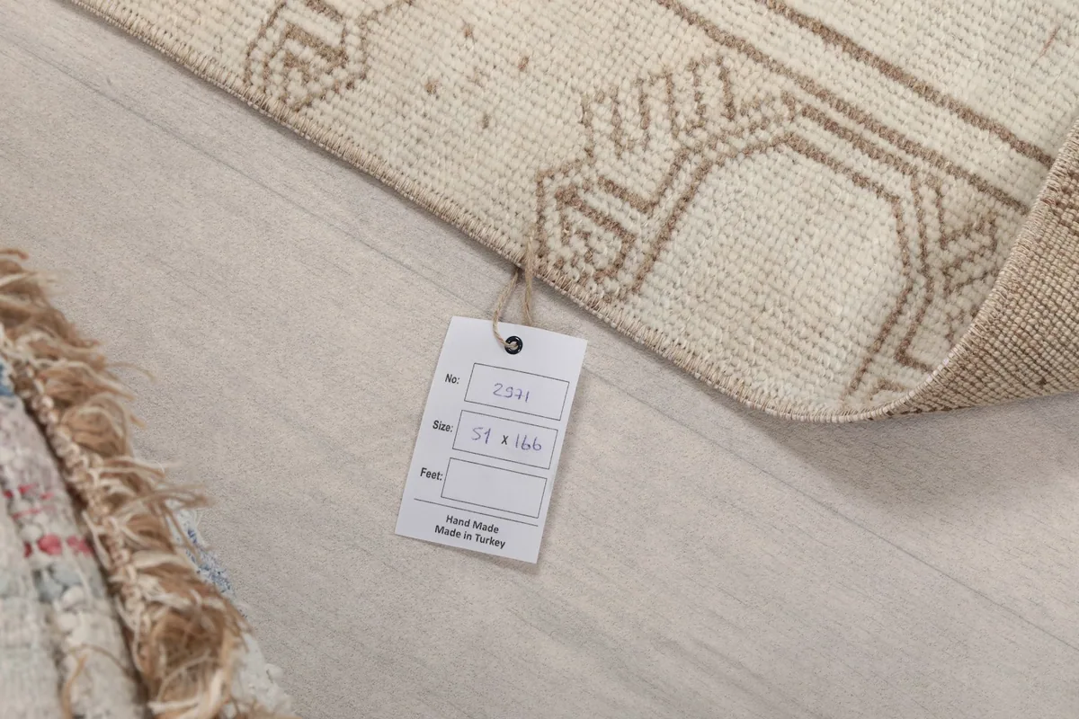 Close-up of the product tag attached to the rug, displaying size information and origin details.