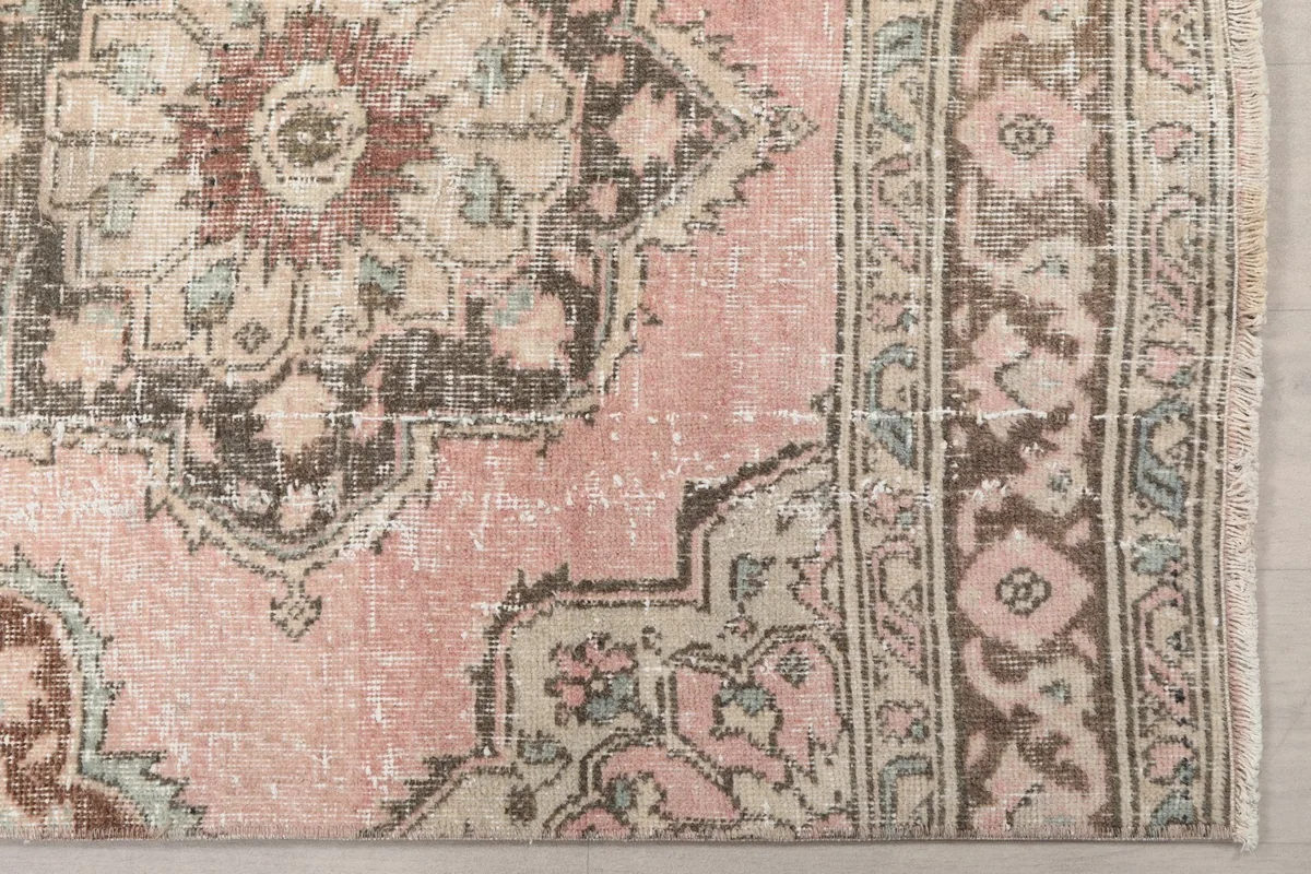 Detailed view of the rose field, brown and beige geometric motifs, and border pattern