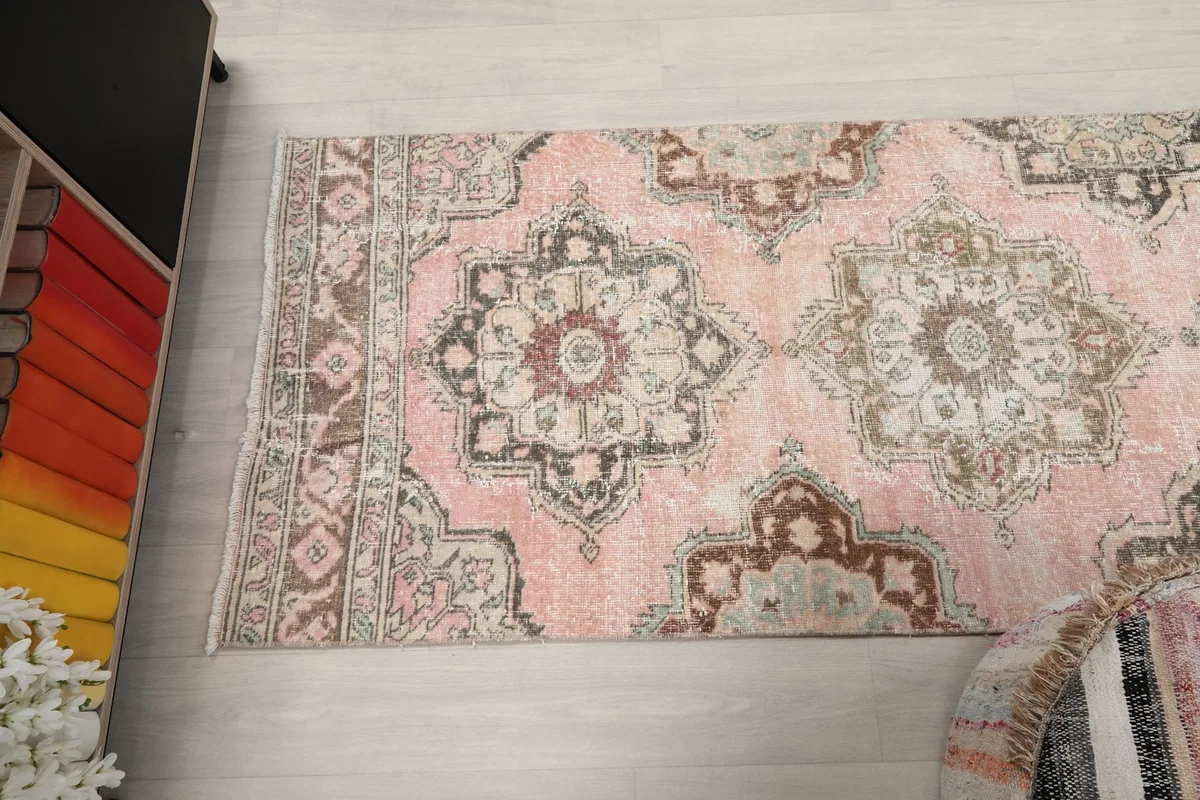 Overhead shot of a section of the rose runner rug, showing repeating medallion designs