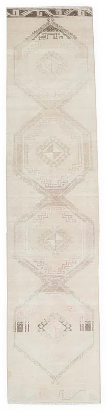 Full overhead view of the beige and brown geometric vintage runner rug on a white background.