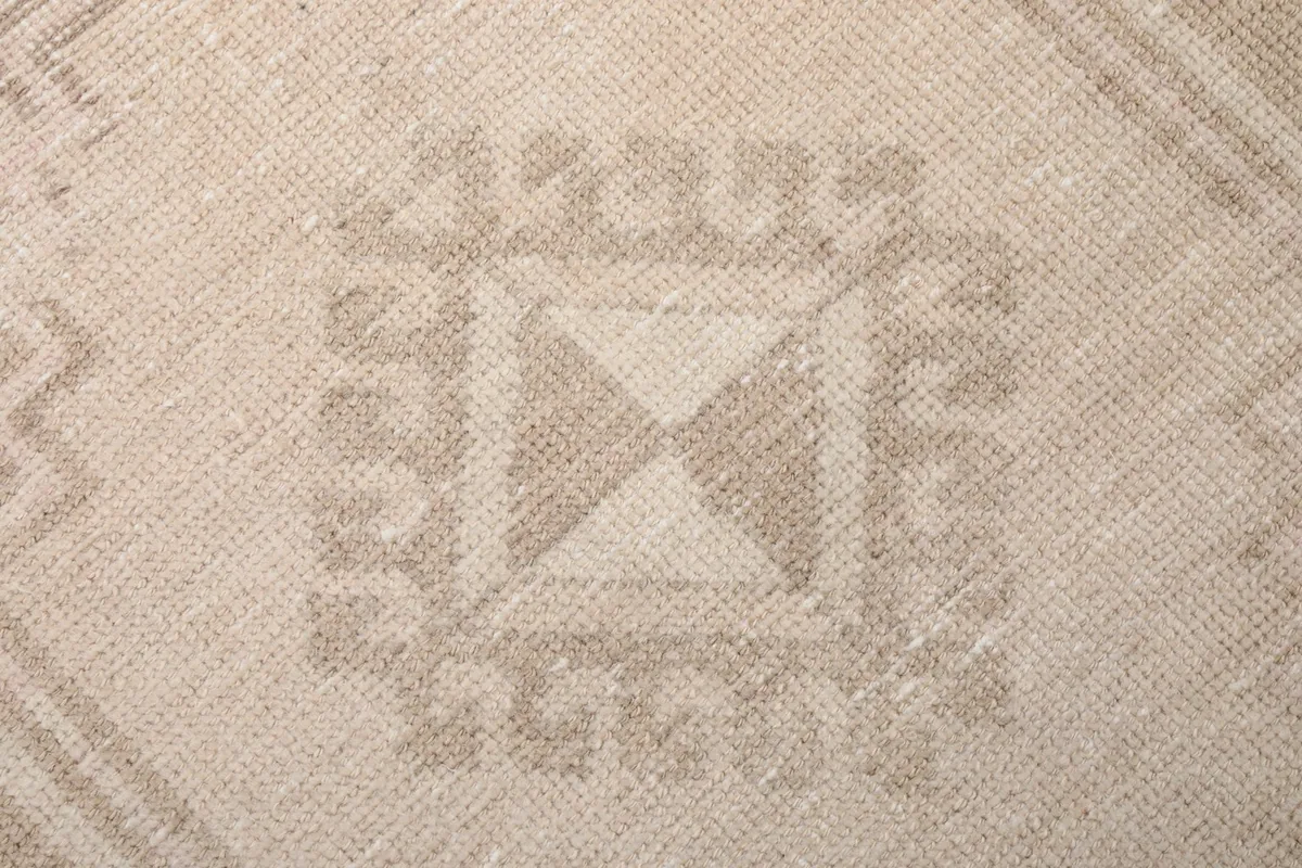 Macro shot highlighting the texture of the low wool pile and the intricate geometric weaving.