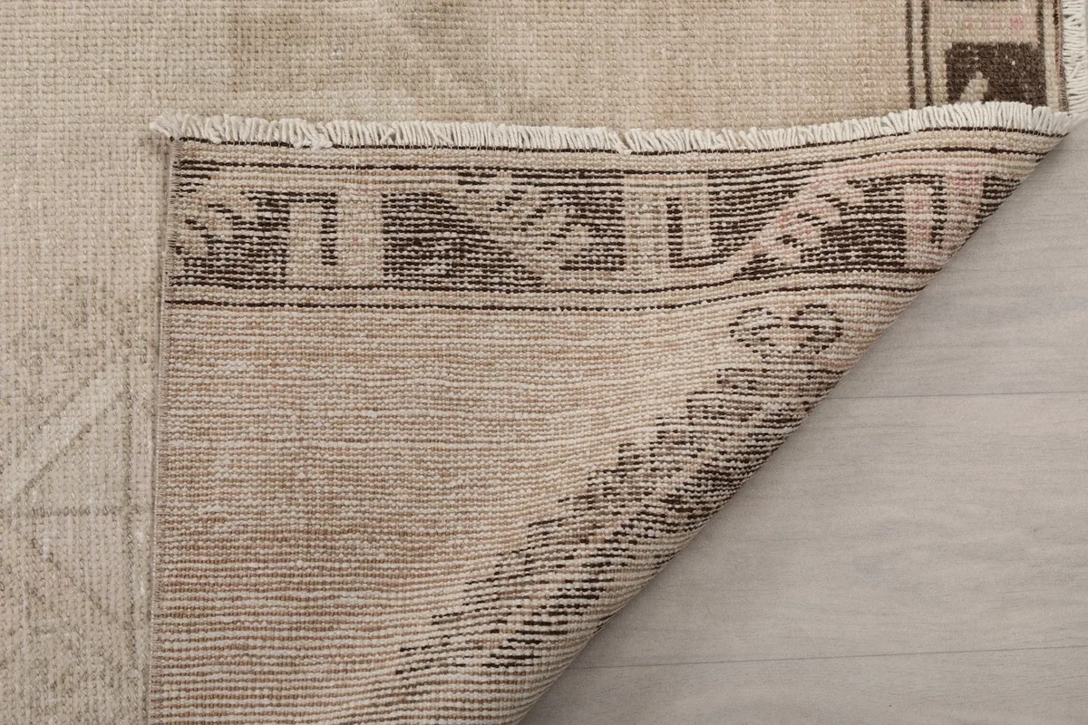 Another view of the rug's reverse, detailing the tight knotting and the structure of the border.