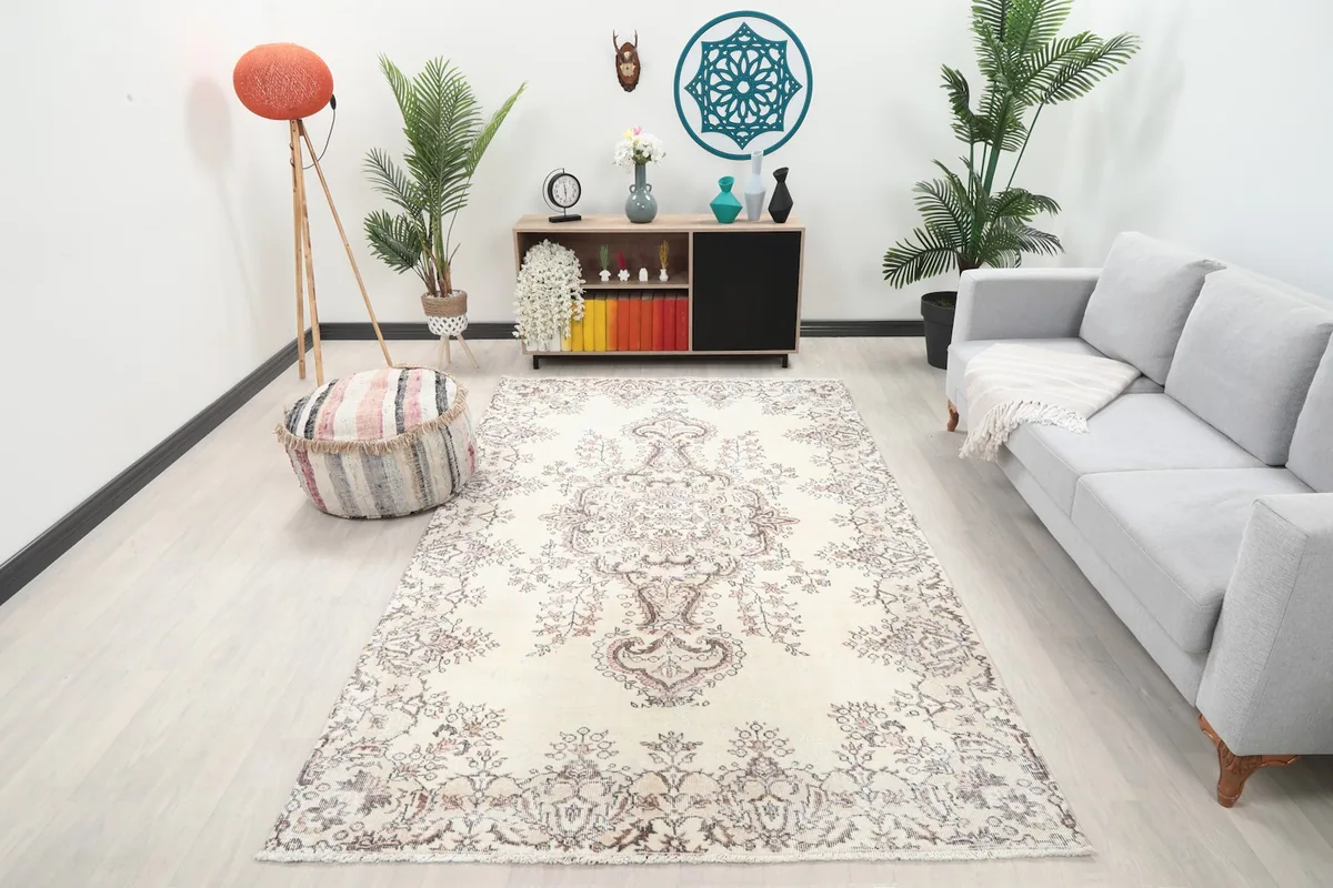 Ivory and rose vintage rug displayed in a living room setting