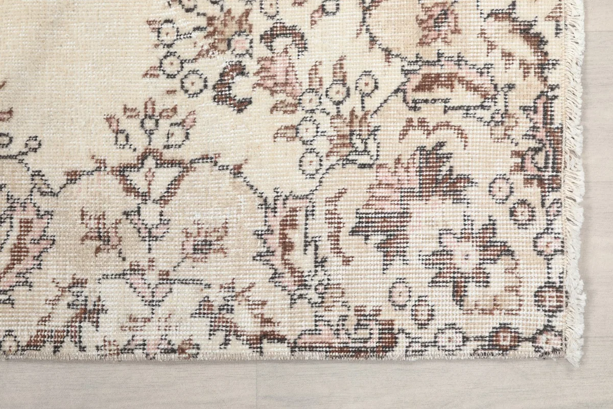 Detailed view of the rug's corner showing floral motifs and fringe