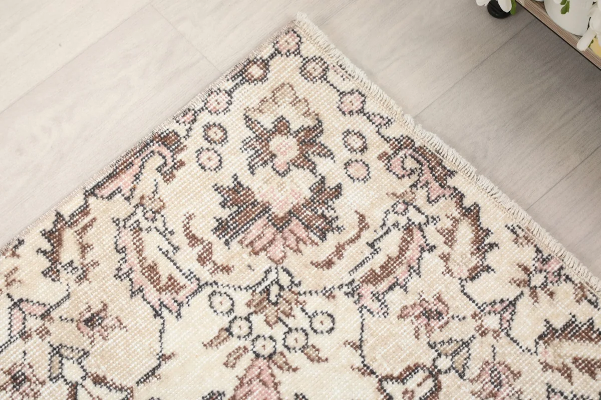Detail of the rug's border pattern in rose and brown tones