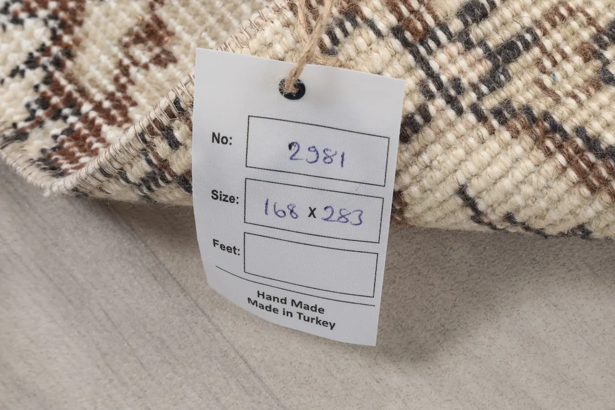 Back of the rug with a tag showing size 168 x 283 cm and origin