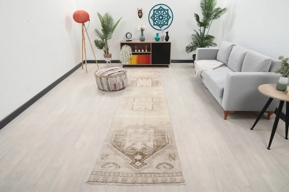 Vintage beige and brown runner rug laid out in a modern living room setting